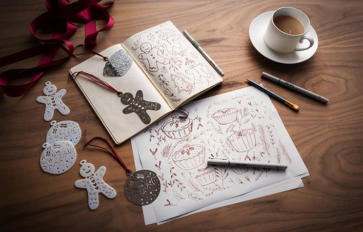 A cozy scene with a notebook, coffee, and Christmas decorations.